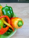 Green, red, yellow bell pepper in a plate on the kitchen work surface Royalty Free Stock Photo