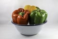 Green, red, yellow bell peppers in white ceramic bowl Royalty Free Stock Photo