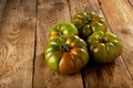 Green ribbed tomatoes on a rustic background