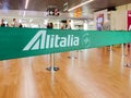 Green ribbon barrier with the Alitalia airline logo inside the Leonardo da Vinci international airport in Rome Fiumicino in Italy