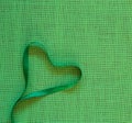Green Ribbon Heart on Burlap Linen Background with copy space. It`s square with a trendy flat layout