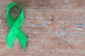 Green ribbon. Scoliosis, Mental health and other, awareness symbo on the wooden background with copy space Royalty Free Stock Photo