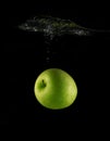 Green ripe apple falls in water Royalty Free Stock Photo