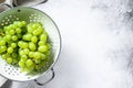 Green ripe grapes in a colander, fruits of autumn. White background. Top view. Copy space Royalty Free Stock Photo