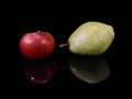 Green ripe pear and apple on a black background. Fruit of fruit trees. Pears and apples are reflected on the glass. Concept: Royalty Free Stock Photo