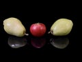 Green ripe pear and apple on a black background. Fruit of fruit trees. Pears and apples are reflected on the glass. Concept: Royalty Free Stock Photo