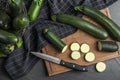 Green ripe zucchinis and wooden board on black slate table, flat lay Royalty Free Stock Photo