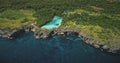 Green rock shore at ocean bay with tropical salt water lake aerial view. Nobody tropical nature