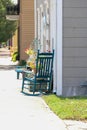 A green rocking chair on the sidewalk