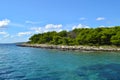 A green rocky island in the azure sea. Blue sky. Croatia. Royalty Free Stock Photo