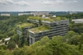 green-roofed building, surrounded by trees and greenery, in modern metropolis Royalty Free Stock Photo