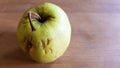 Green rotten apple on a wood background. Green apple on a old wooden background, top view. Organic juicy bio apple ugly, with