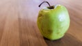 Green rotten apple on a wood background. Green apple on a old wooden background, top view. Organic juicy bio apple ugly, with