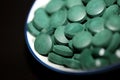Green round healthy pills macro medical spirulina platensis space food modern high quality instant prints tablets background top