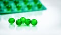 Green round soft capsule pills on blurred background of blister pack with space. Ayurvedic medicine for indigestion, gas Royalty Free Stock Photo