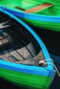 Green rowing boats tied to pier