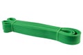 Green rubber band for fitness, resistance expander, the tourniquet is folded, on a white background