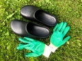 Green rubber construction gloves next to black rubber overshoes. harvesting in autumn. protection of the skin of the hands and