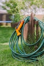 A green rubber garden hose with nozzle Royalty Free Stock Photo