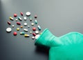 Green rubber hot water bottle with pills Royalty Free Stock Photo