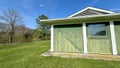 green rustic shed with bright blue sky