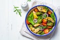 Green salad with artichokes, tomatoes and olives in white bowl Royalty Free Stock Photo