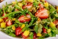 Green salad with arugula, strawberries, mango and pistachios