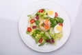 Green salad with eggs in the shape of a heart, salmon, cherry tomatoes