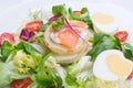 Green salad with eggs in the shape of a heart, salmon, cherry tomatoes