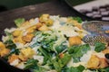 Green salad with fried tofu in a black bowl. Marinated Asian tofu salad at restaurant buffet