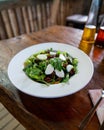 Green salad with many toppings at greek restaurant with cheese, tomatoes, and greens