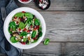 Green salad spinach bowl with quinoa, pomegranate, walnuts, feta cheese and dried cranberries.