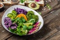 Green salad with sweet potatoes, broccoli, avocado, purple cabbage, cucumber, watermelon radish and almonds. Food recipe