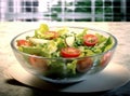 Green salad with tomato and fresh vegetables isolated on white background. Created with Generative AI technology. Royalty Free Stock Photo