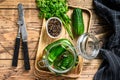 Green salted cucumbers in a glass jar. Wooden background. Top view