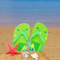 Green sandals and starfish in sand Royalty Free Stock Photo