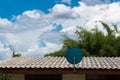 Green Satellite dish on the roof with a beautiful blue sky. Royalty Free Stock Photo