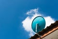 Green Satellite dish on the roof with a beautiful blue sky. Royalty Free Stock Photo