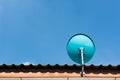 Green Satellite dish on the roof with a beautiful blue sky. Royalty Free Stock Photo