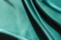 Green satin fabric pleats close-up. Abstract trend background of the 2021 Tidewater Green color