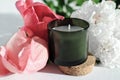 green scented candle and peony flowers. home fragrances for relaxation and calm. flower fragrance for home. unbranded