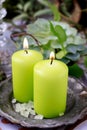 Green scented candles on silver plate