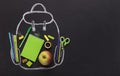 Green school stationery inside chalk painted backpack on black Royalty Free Stock Photo