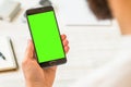 Green screen for chroma key compositing A black smartphone with green screen for chroma key compositing