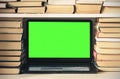 Green screen laptop, stack of books, notebook and pencils on white table, education office concept background