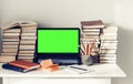 Green screen laptop, stack of books, notebooks and pencils on white table, education office concept background Royalty Free Stock Photo