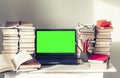 Green screen laptop, stack of books, notebooks and pencils on white table, education office concept background Royalty Free Stock Photo