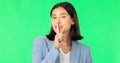 Green screen, secret and wink face of happy woman, privacy and finger on lips in studio. Portrait of female model