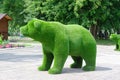 Green sculpture in the shape of a bear in the city park. Selective Focus