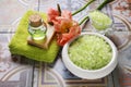 Green sea salt, soft towel, bottle of essential oil, bar of soap and poppy flower Royalty Free Stock Photo